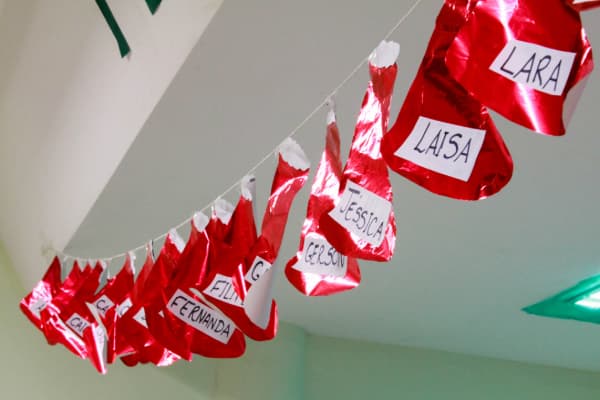 Decoracao de Natal Para Sala de Aula com gorrinhas de papel e o nome das criancas
